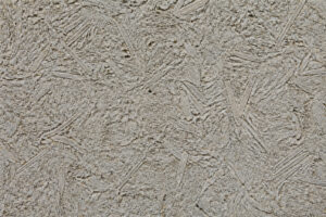 Gros plan sur une texture de béton de bois rugueuse avec des copeaux de bois visibles dans le mortier gris.